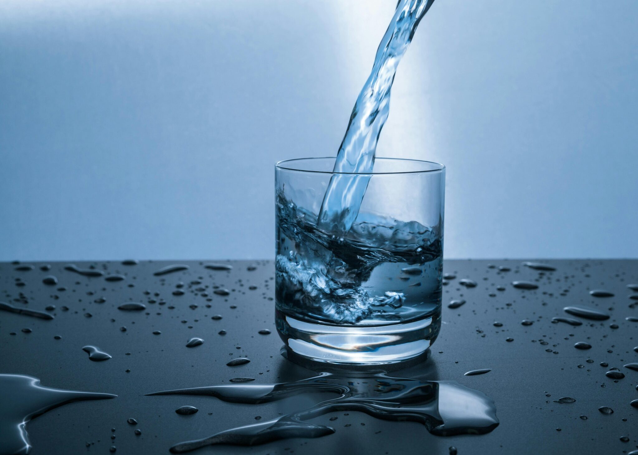 Жінка п’є воду зі склянки