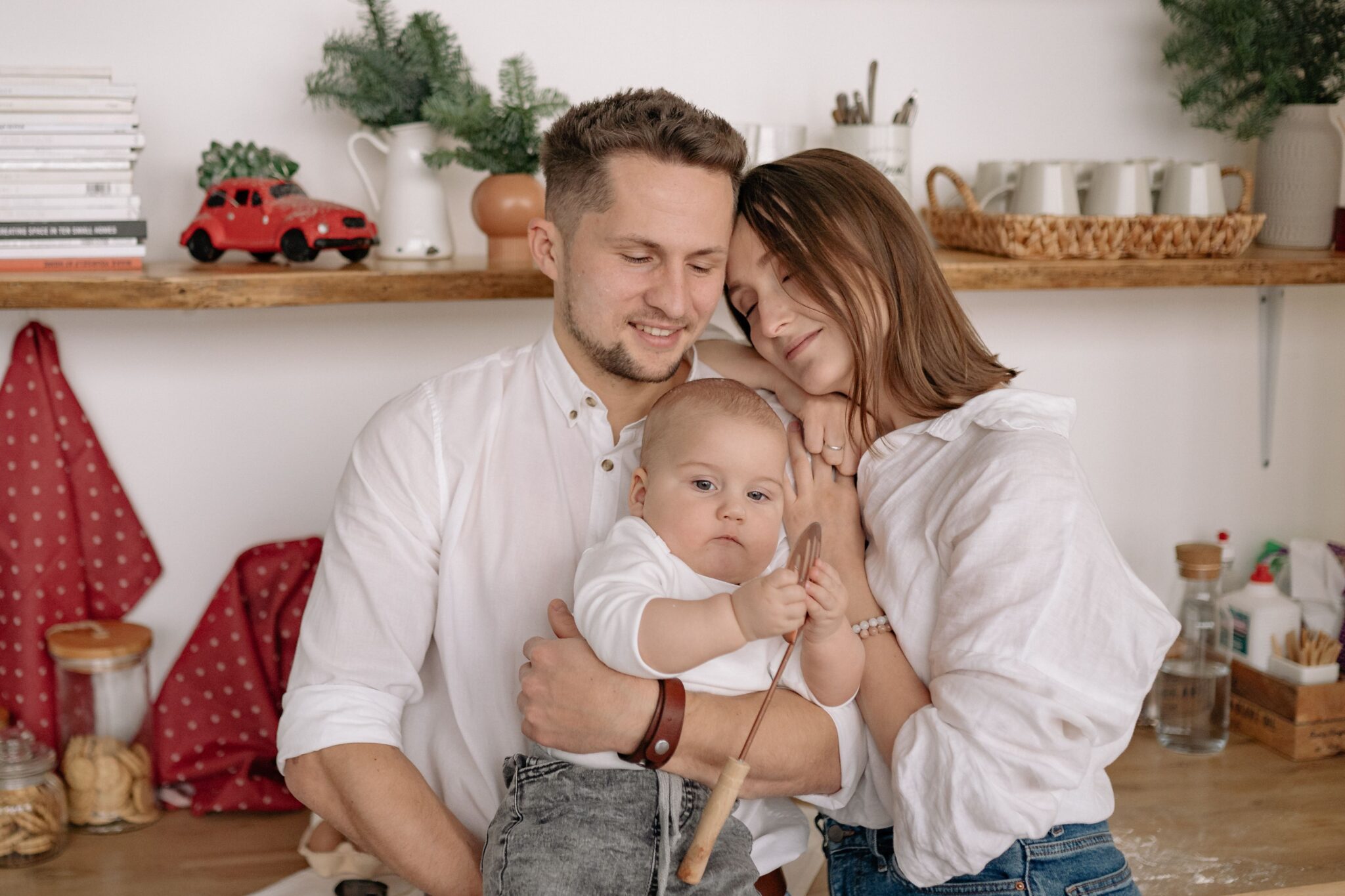 молоді батьки на кухні тримають немовля